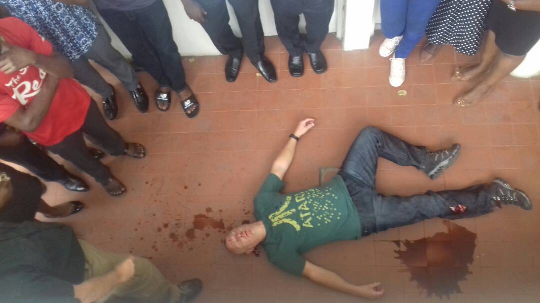 Man lying on floor, blood near leg, unresponsive.